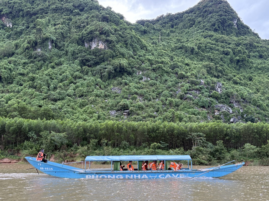 Boottocht met gezin op de rivier langs groene kalksteenbergen in Vietnam.
