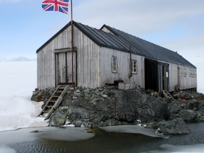 Britse onderzoeksbasis op rotsen aan de kust van Antarctica, met Union Jack-vlag.