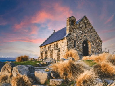 Stone Church of the Good Shepherd bij Lake Tekapo in Nieuw-Zeeland bij zonsondergang.