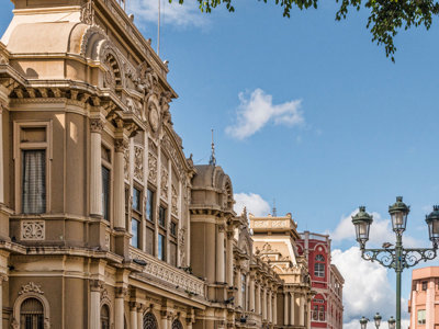Historische gevels en straatlantaarns in San José, Costa Rica, onder een blauwe lucht.