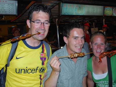 Reizigers proeven streetfood op een avondmarkt in China tijdens de 17-daagse Route China.