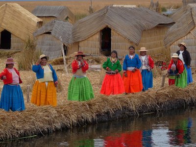 Bewoners op de rieteilanden van het Titicacameer bij Puno, Peru, met traditionele kleding en rieten huizen.
