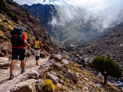 Wandelaars met rugzakken op bergpad in het Atlasgebergte tijdens de beklimming van Mount Toubkal, Marokko.