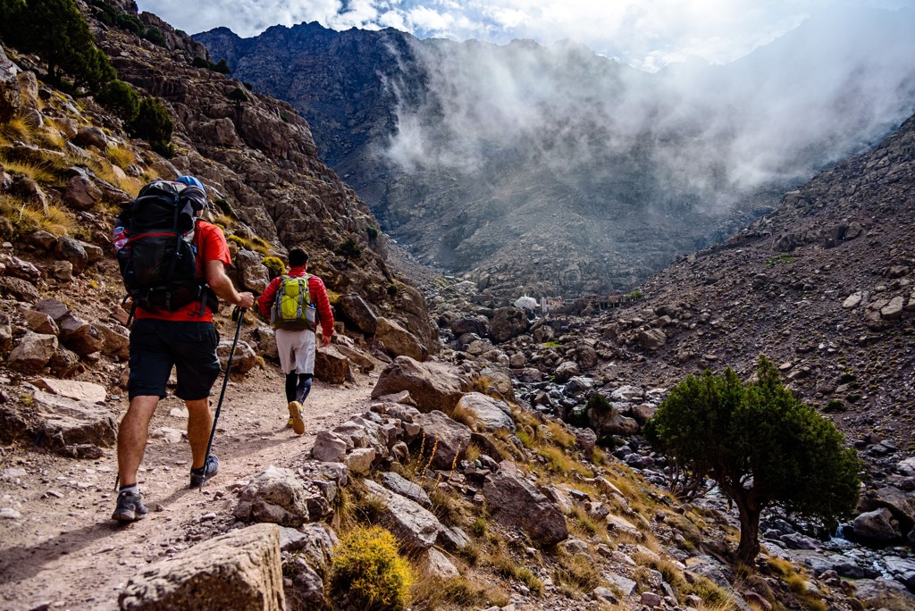 Wandelaars met rugzakken op bergpad in het Atlasgebergte tijdens de beklimming van Mount Toubkal, Marokko.