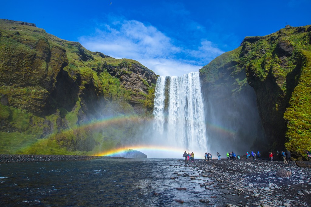 Waterval Skógafoss in IJsland met regenboog en wandelaars tijdens de Laugavegur Trail.