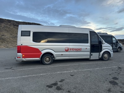 Minibus voor groepsreizen in IJsland, geparkeerd langs de weg in een ruig landschap.