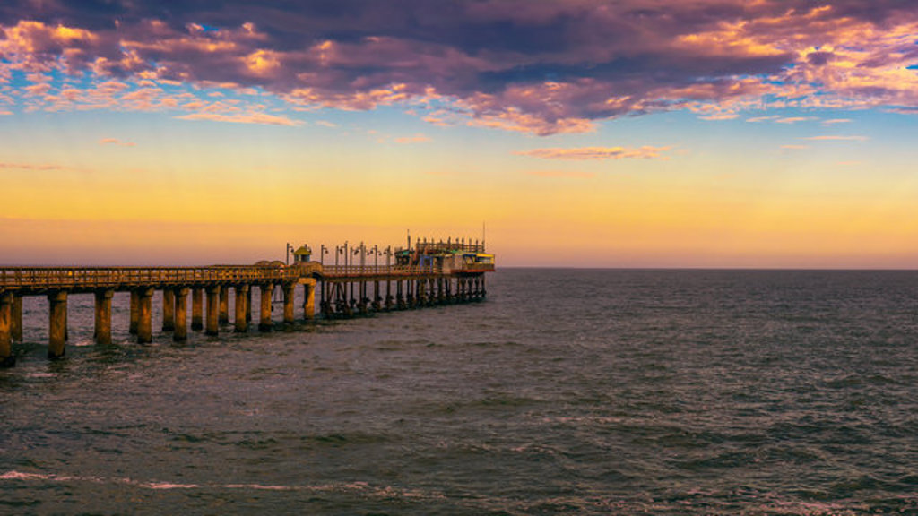 Pier in Swakopmund aan de Atlantische Oceaan bij zonsondergang tijdens de 22-35ers reis Zuidelijk Afrika.