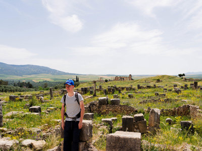 Wandelaar tussen de Romeinse ruïnes van Volubilis op de route door Marokko.