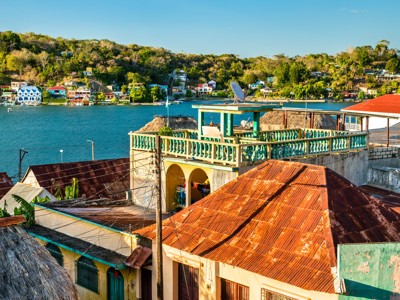 Uitzicht over het meer van Río Dulce met kleurrijke huizen en groene heuvels in Guatemala.