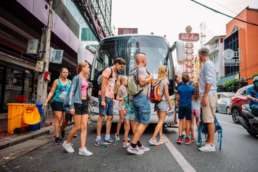 Familiegroep stapt in Thailand uit een touringcar in de stad tijdens de Familiereis Thailand Chill & Adventure.
