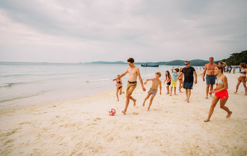 Gezin speelt voetbal op het strand in Zuid-Thailand tijdens familiereis Thailand Noord en Zuid.