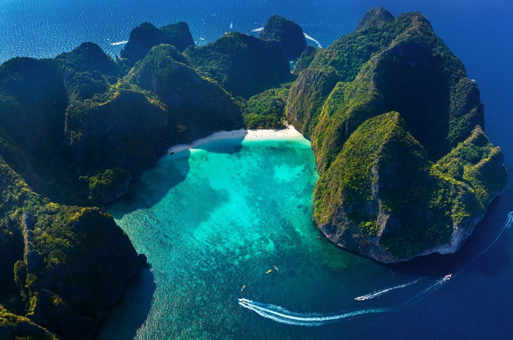 Maya Bay op Koh Phi Phi Leh, Thailand, met wit strand en turquoise lagune omringd door kliffen.