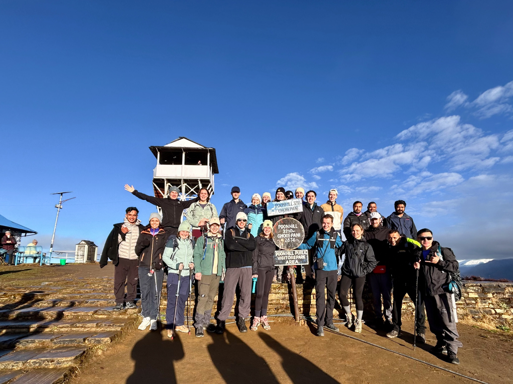 Groepsfoto van wandelaars bij Poon Hill (3210 m) tijdens een 22-35ers reis in Nepal.