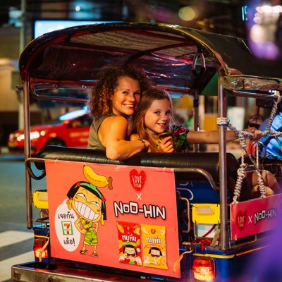 Moeder en dochter in een tuktuk tijdens een avondrit in Thailand, onderdeel van de Familiereis Thailand.