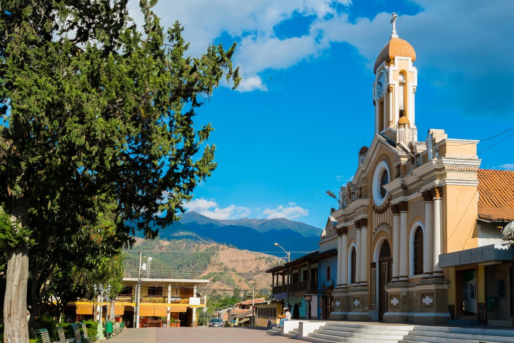 Kerk op het centrale plein van Alausí in Ecuador, met bergen op de achtergrond.