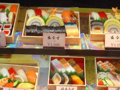 Assortiment sushi in houten bentoboxen met prijskaartjes in yen, Route Japan dag 3.