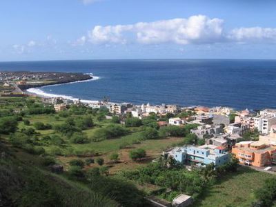 Uitzicht op kustplaats aan de Atlantische Oceaan op de Kaapverdische eilanden, met baai, strand en huizen.