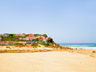 Zandstrand met kustdorpje en kliffen aan de Costa Vicentina, Alentejo en Algarve, Portugal.