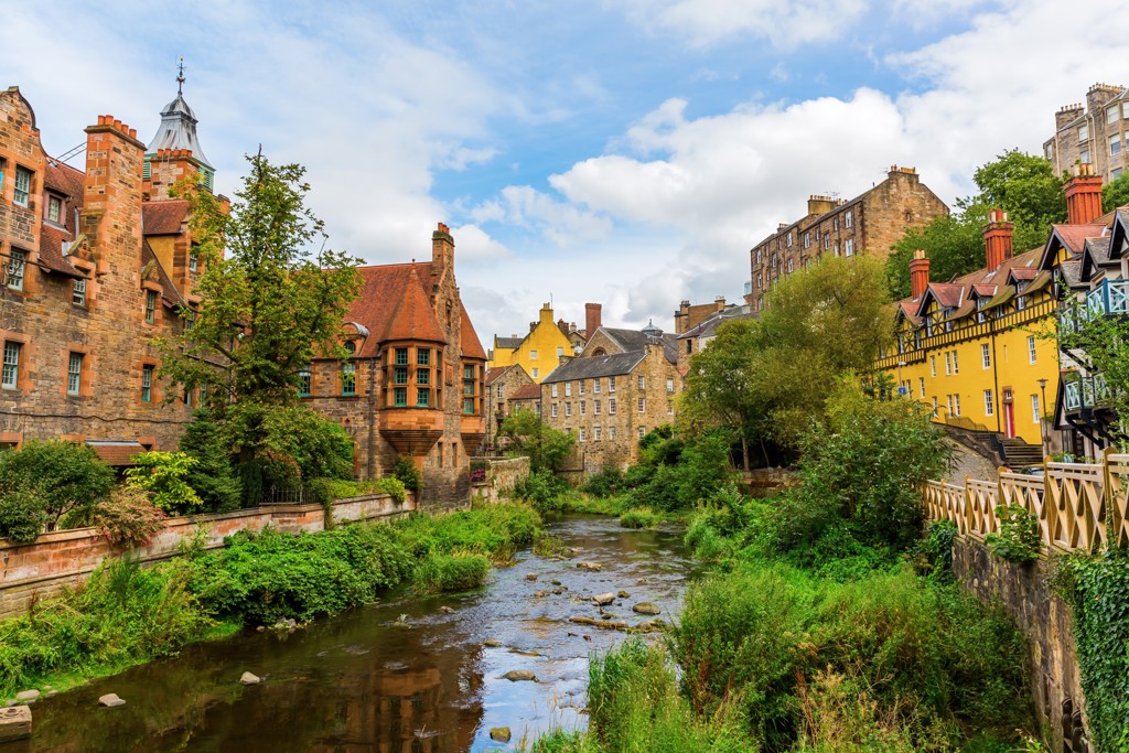 Uitzicht op Dean Village in Edinburgh met kleurrijke huizen langs de Water of Leith, tijdens een groepsrondreis Verenigd Koninkrijk.