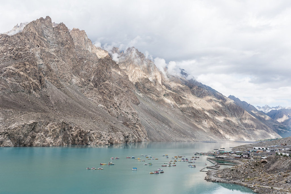 Turquoise Attabad Lake in Hunza, Pakistan, met steile bergen en kleurrijke bootjes op het water.