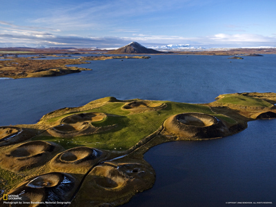 Groene pseudokraters bij het Mývatn-meer in Noord-IJsland, met vulkanisch landschap en bergen op de achtergrond.