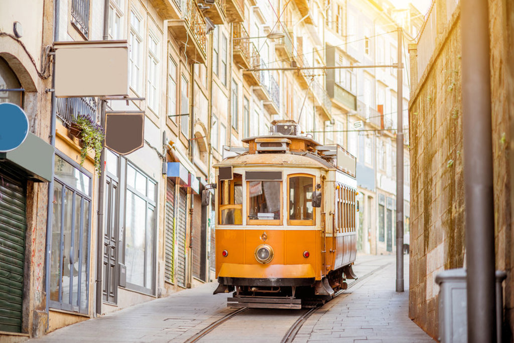 Gele tram in een smalle straat in Lissabon, Portugal.