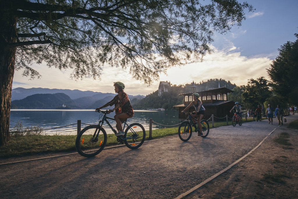 Fietsers langs het Meer van Bled in Slovenië tijdens zonsondergang.