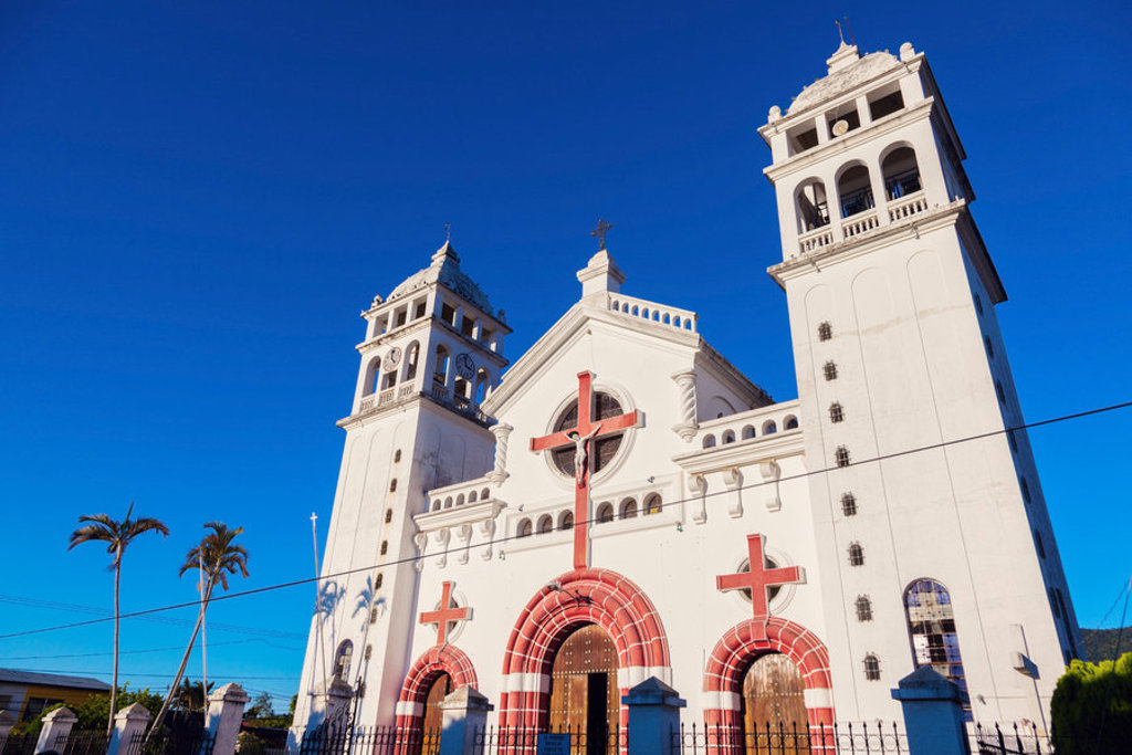 Witte kathedraal met twee torens en rode kruisdetails, tijdens 22-35ers reis Guatemala, Honduras en El Salvador.