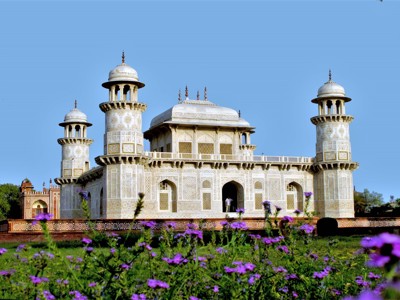 Baby Taj (Itimad-ud-Daulah) in Agra met bloeiende paarse bloemen op de voorgrond.