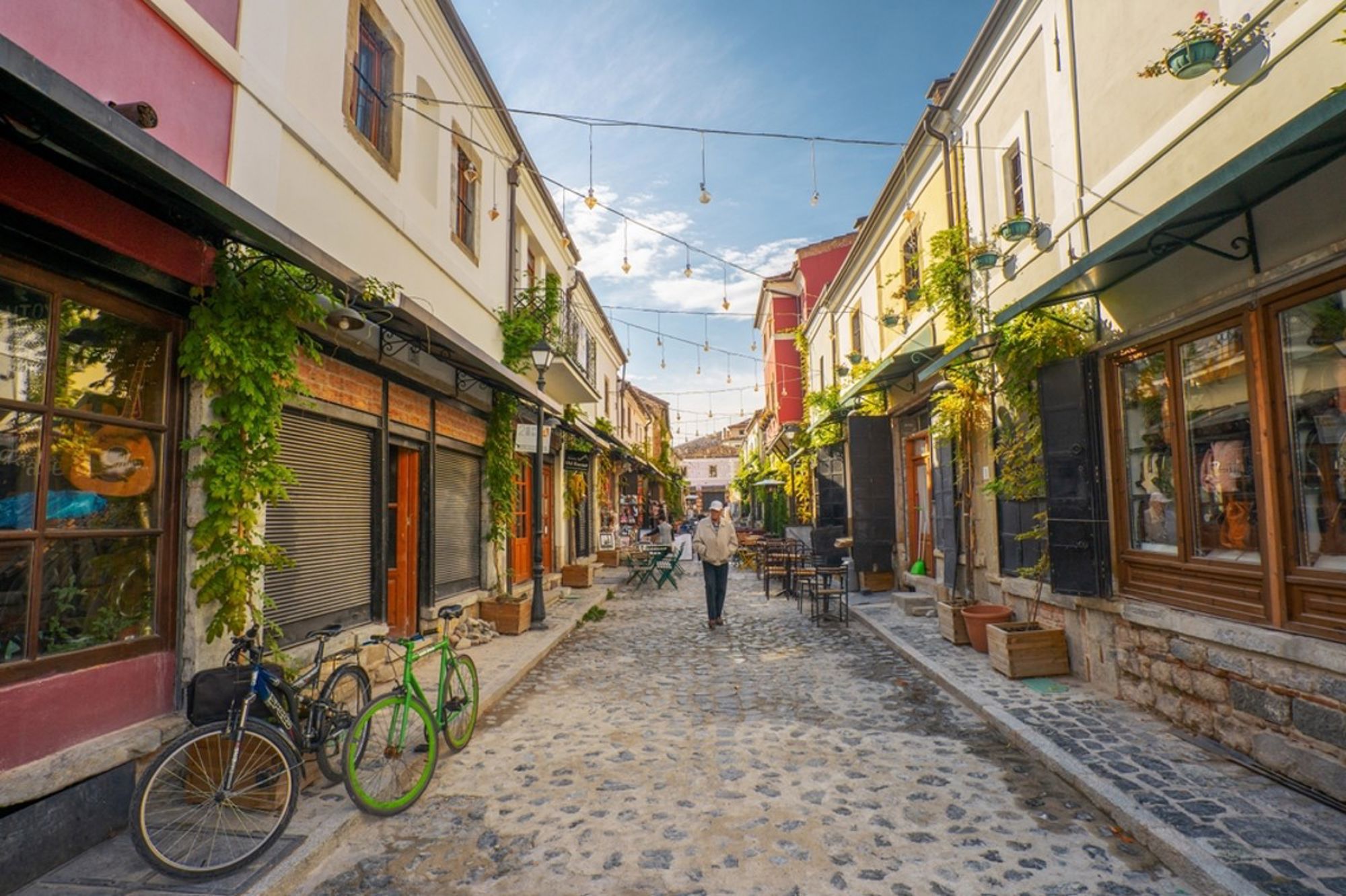 Gezellige geplaveide straat met cafés en klimplanten in de oude stad van Berat, Albanië.
