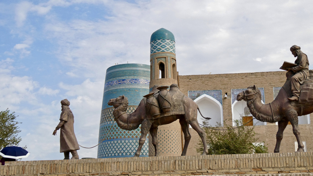 Karavaanbeeld met kamelen bij de Kalta Minor-minaret in Khiva, Oezbekistan.