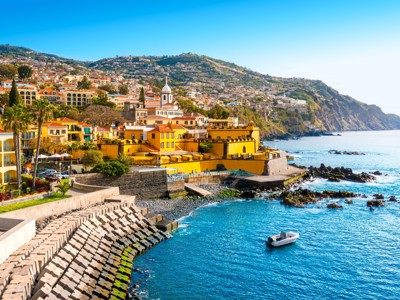Uitzicht op de kust van Funchal op Madeira met kleurrijke huizen en de Atlantische Oceaan.