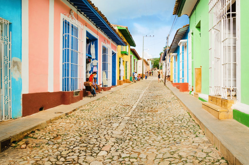 Gekleurde huizen langs een geplaveide straat in Trinidad, Cuba.