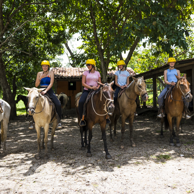 Gezin te paard op een ranch in Costa Rica tijdens een familiereis.