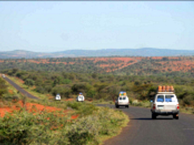 Jeeps op een asfaltweg door het groene landschap van Ethiopië tijdens de route van 29 dagen.