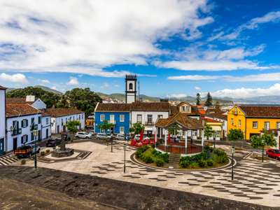 Centraal plein in Ribeira Grande op São Miguel, Azoren, met kiosk, kerk en kleurrijke huizen.