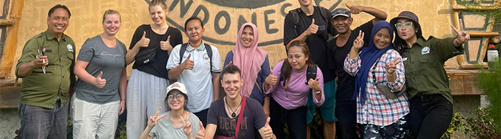 Groepsfoto van Sawadee-reizigers en lokale partners bij een duurzaam project, met duim omhoog.