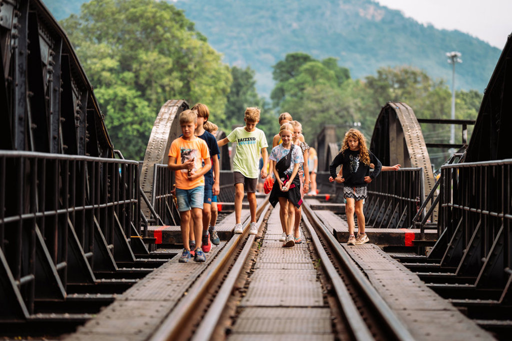 Kinderen wandelen over de spoorbrug bij de River Kwai in Thailand tijdens de Familiereis Thailand Chill & Adventure.