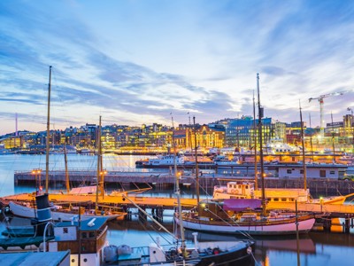 Verlichte haven van Oslo bij schemering met aangemeerde schepen, startpunt van de Spitsbergen-cruise.