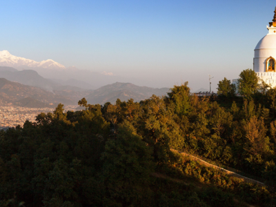 Witte stoepa op een heuvel bij Kathmandu, met uitzicht op de Himalaya tijdens de route India en Nepal.