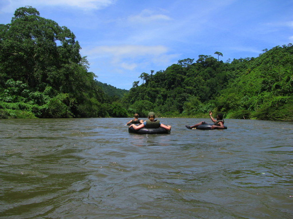 Tubing op een rivier door het groene regenwoud tijdens een familiereis in Colombia.