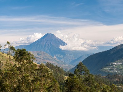 Uitzicht op een vulkaan in de Andes van Ecuador, omringd door valleien en wolken.