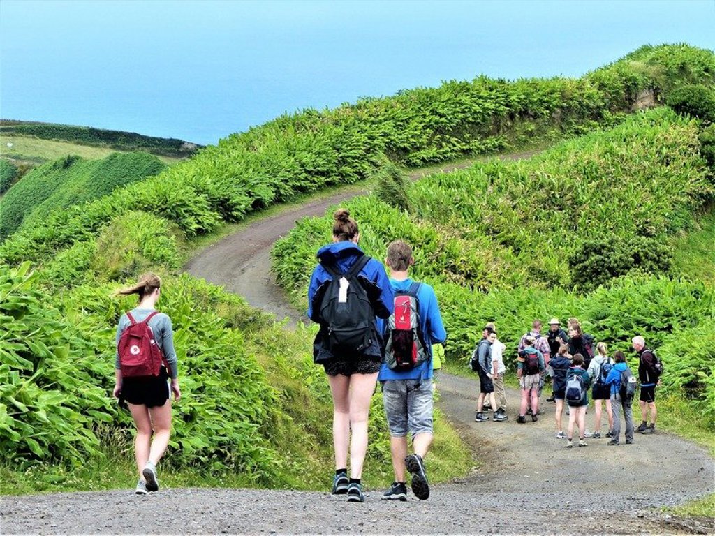 Wandelaar op pad door groen berglandschap op São Miguel, Azoren.