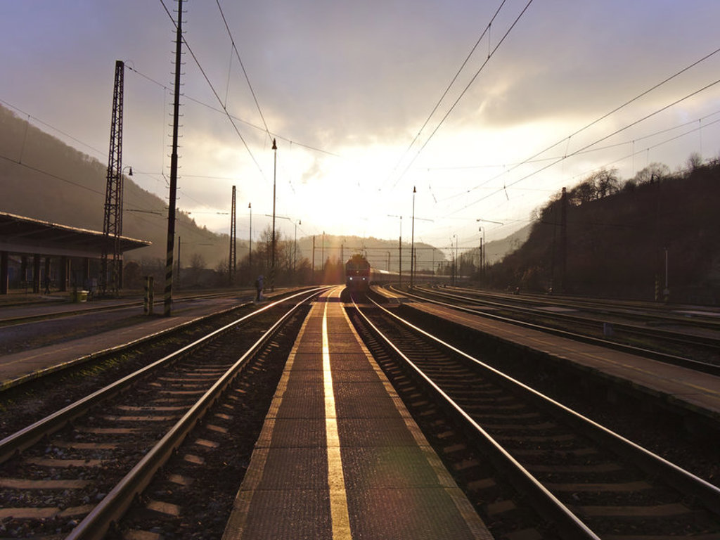 Trein op een spoorwegstation bij zonsopkomst tijdens een groepsrondreis door Centraal-Europa met de trein.