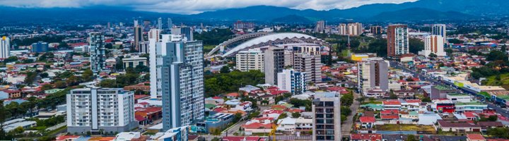 Skyline van San José, Costa Rica, met het Nationaal Stadion en bergen op de achtergrond.