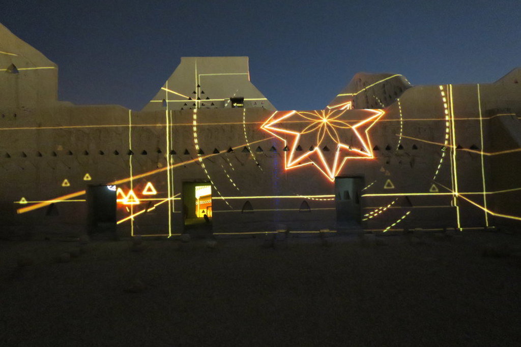 Lichtprojectie op een fortmuur tijdens een avondbezoek in Saoedi-Arabië.