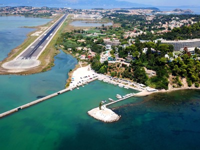 Corfu met landingsbaan langs zee, jachthaven en kustplaats in de Ionische Zee.