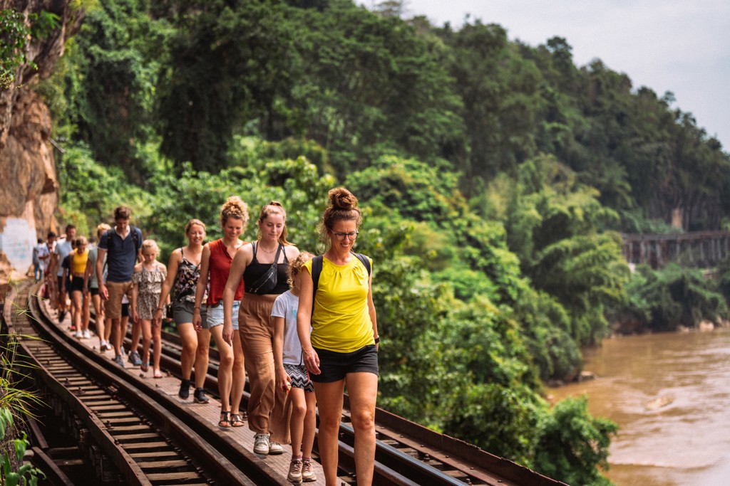 Gezin wandelt over de spoorlijn langs de River Kwai in Thailand tijdens de familiereis Thailand Hoogtepunten.