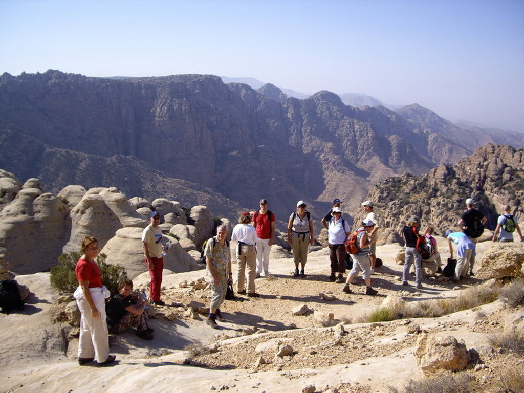 Groep wandelaars tijdens groepsrondreis Jordanië met uitzicht op de bergen en rotsformaties.