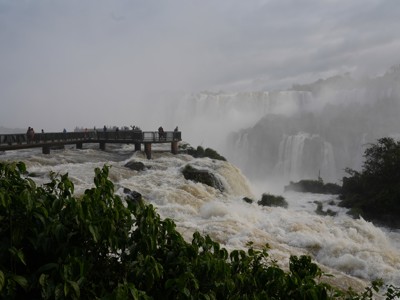 Uitzichtplatform bij de Iguazú-watervallen op de route door Argentinië, met mist en kolkend water.